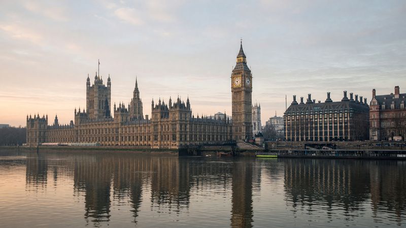 The Houses of Parliament and Elizabeth Tower (Big Ben) reflected in the River Thames.